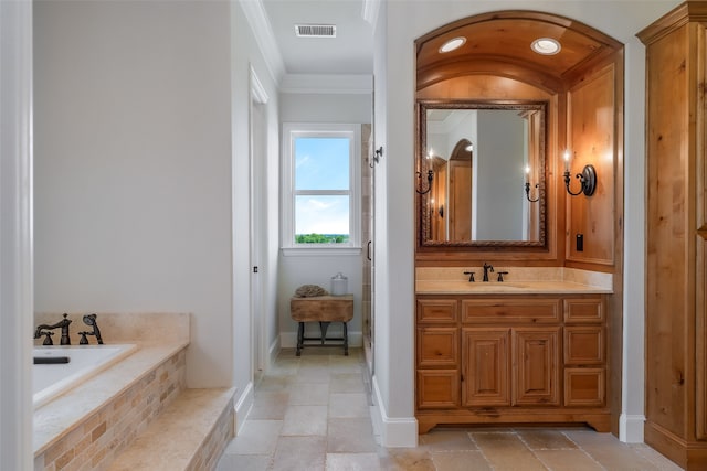 bathroom featuring vanity, crown molding, and tiled tub