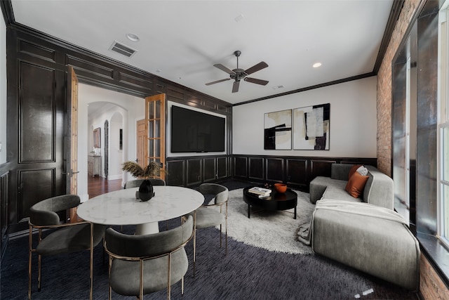 living room with carpet flooring, ceiling fan, and ornamental molding