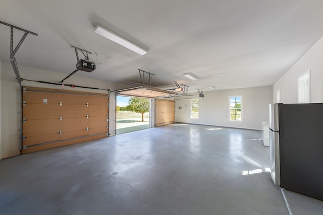 garage featuring stainless steel fridge and a garage door opener