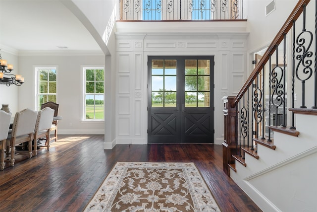 entrance foyer with a chandelier, french doors, dark hardwood / wood-style flooring, and crown molding