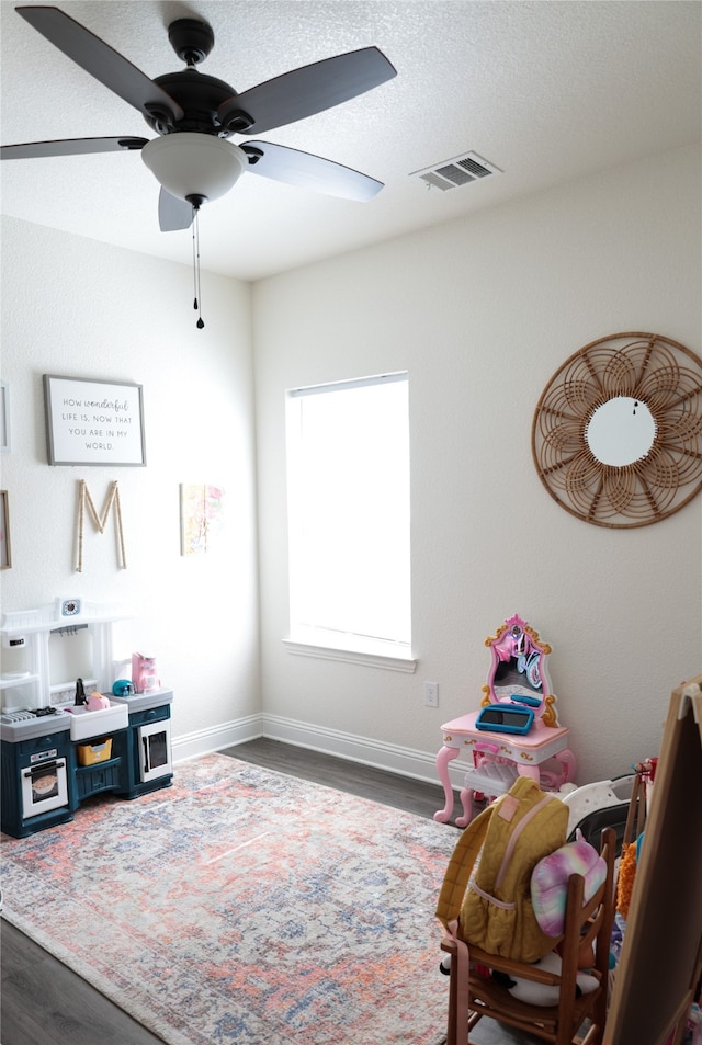 playroom featuring ceiling fan and dark hardwood / wood-style floors