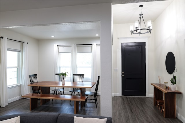 dining room with dark hardwood / wood-style floors and an inviting chandelier