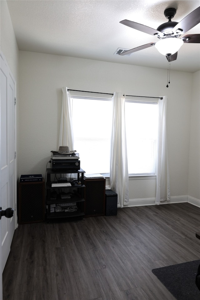 interior space with ceiling fan and dark wood-type flooring