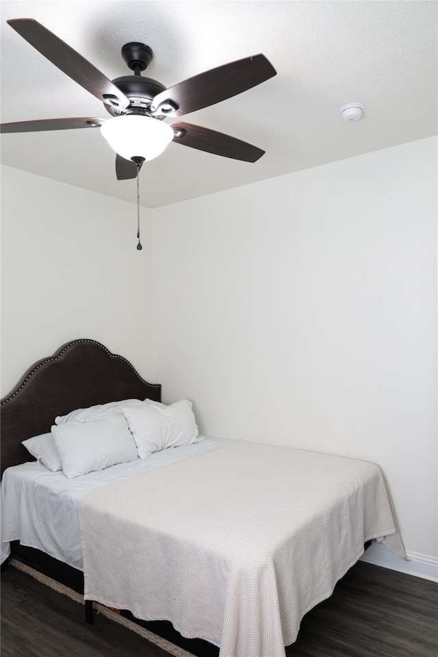 bedroom with dark hardwood / wood-style floors and ceiling fan