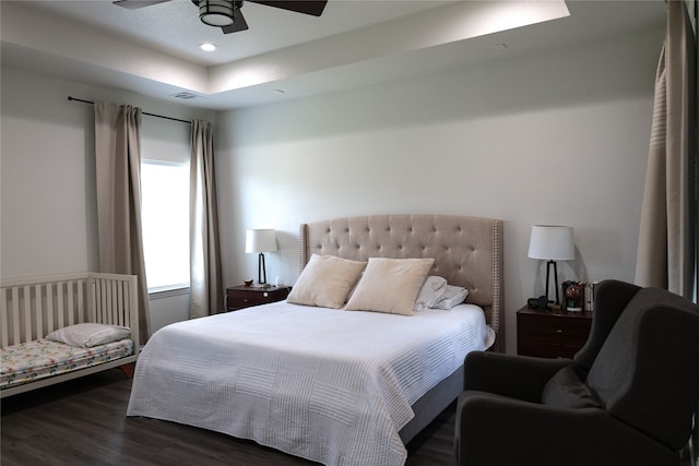 bedroom with dark hardwood / wood-style floors and ceiling fan