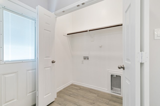 laundry room featuring washer hookup and light hardwood / wood-style flooring