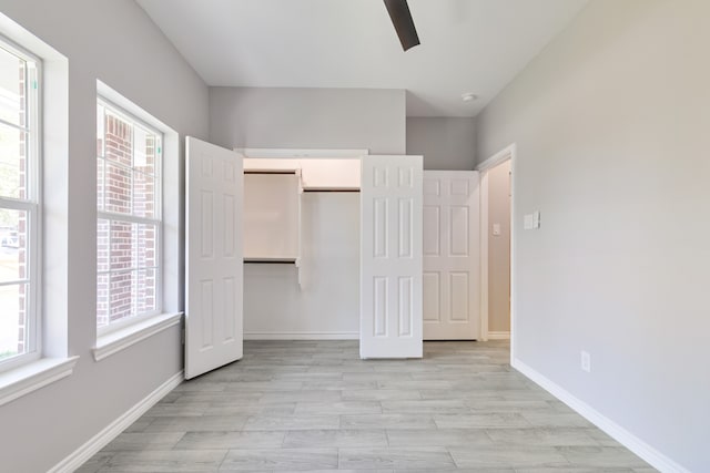 unfurnished bedroom with ceiling fan, light wood-type flooring, and a closet