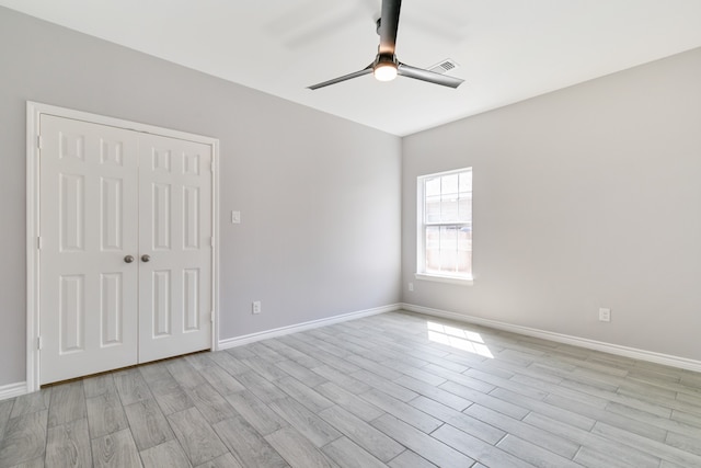 empty room with light wood-type flooring and ceiling fan