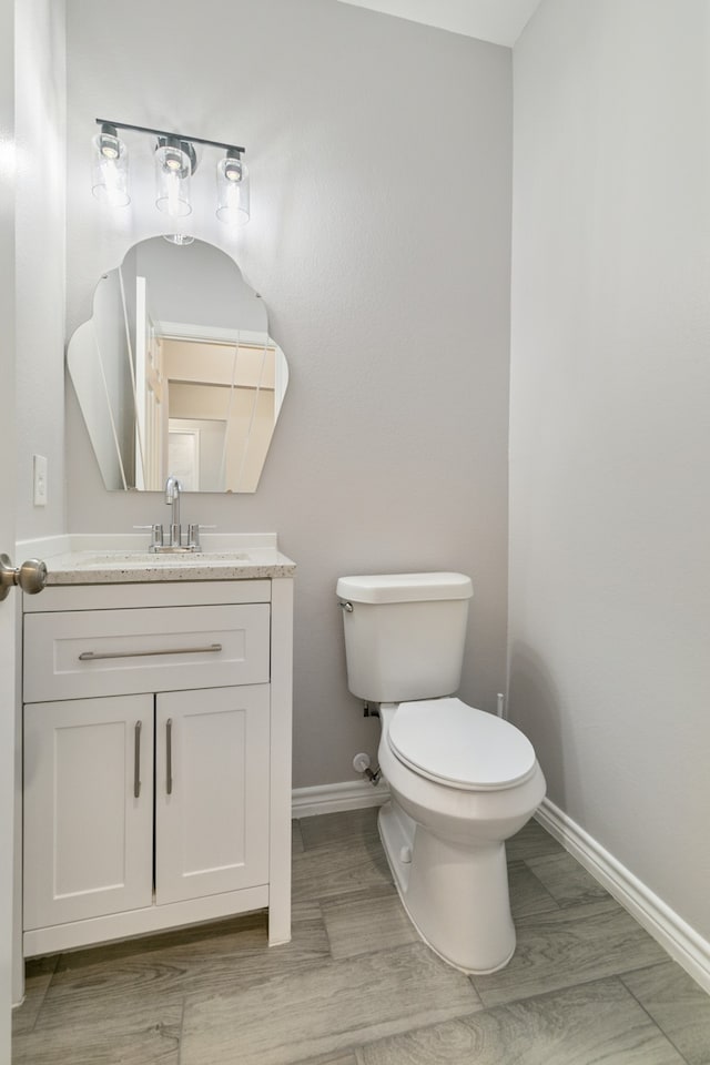 bathroom featuring hardwood / wood-style flooring, vanity, and toilet