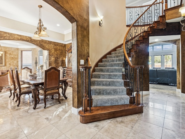 stairway featuring tile patterned flooring, a high ceiling, and crown molding