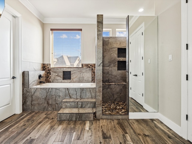 bathroom with wood-type flooring, a relaxing tiled tub, and crown molding