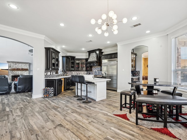 dining space featuring light hardwood / wood-style floors, an inviting chandelier, ornamental molding, and sink