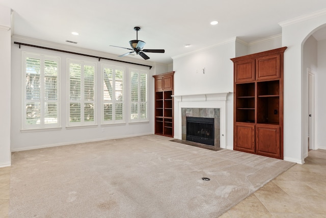 unfurnished living room with light colored carpet, ornamental molding, and a tiled fireplace