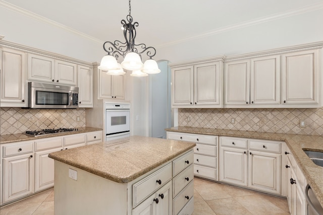 kitchen featuring backsplash, ornamental molding, stainless steel appliances, a center island, and hanging light fixtures