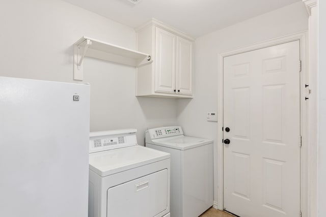 washroom featuring cabinets and independent washer and dryer