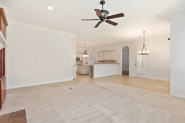 unfurnished living room with ceiling fan, light colored carpet, and ornamental molding