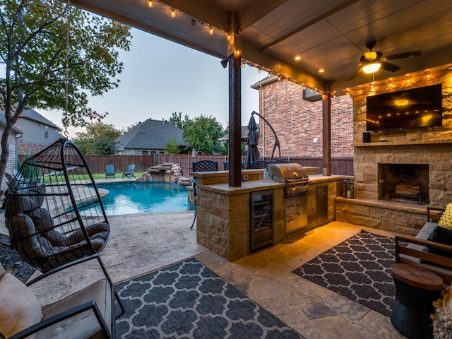 patio terrace at dusk featuring ceiling fan, grilling area, a fenced in pool, pool water feature, and wine cooler