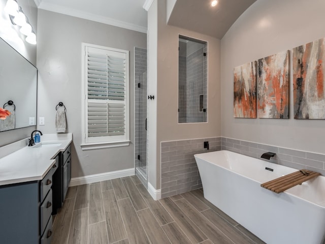 bathroom featuring hardwood / wood-style floors, ornamental molding, vanity, and plus walk in shower