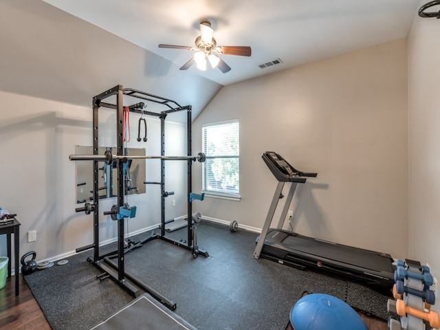 exercise room featuring ceiling fan, vaulted ceiling, and dark hardwood / wood-style flooring