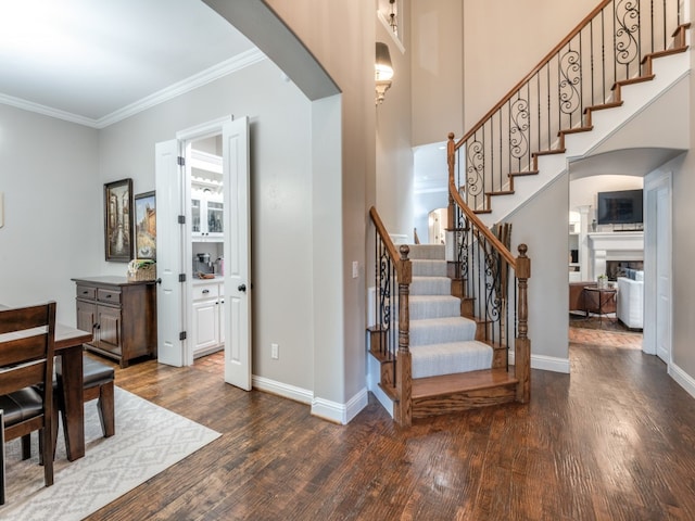 staircase with ornamental molding and hardwood / wood-style flooring