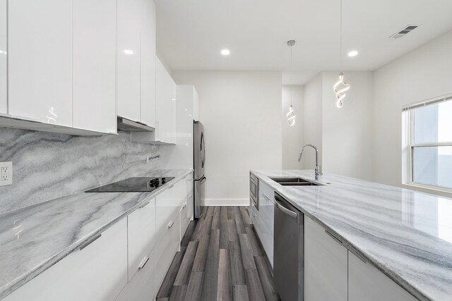 kitchen with hanging light fixtures, sink, extractor fan, white cabinetry, and stainless steel appliances