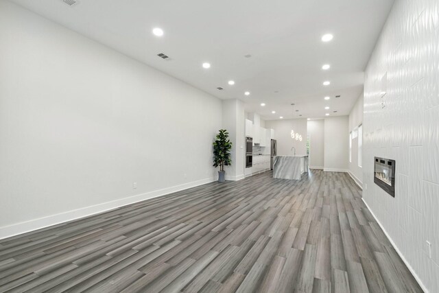 2507 Crossman Ave, Dallas, TX 75212 - unfurnished living room with recessed lighting, wood finished floors, a large fireplace, and baseboards