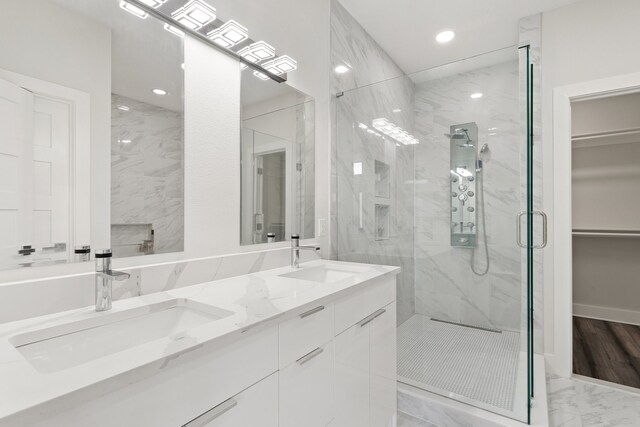 bathroom featuring hardwood / wood-style floors, a shower with shower door, and vanity