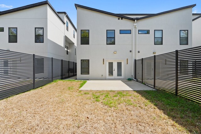 rear view of property with a yard, french doors, and a patio area