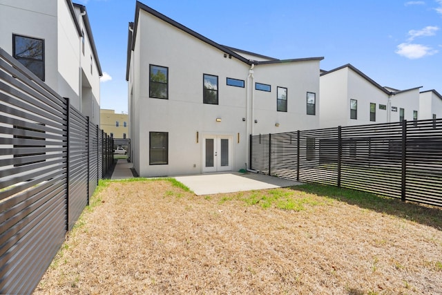 2507 Crossman Ave, Dallas, TX 75212 - back of property featuring french doors, stucco siding, a fenced backyard, and a patio area