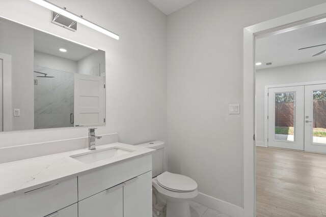 bathroom featuring walk in shower, toilet, wood-type flooring, french doors, and vanity