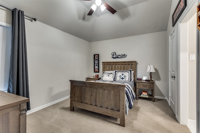 carpeted bedroom with ceiling fan and vaulted ceiling