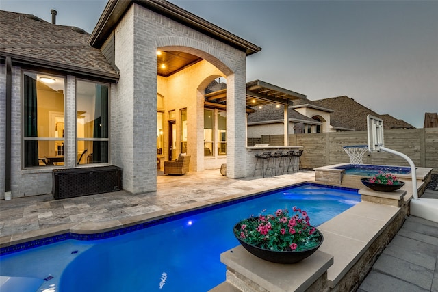 view of swimming pool with a patio, an in ground hot tub, exterior bar, and a pergola