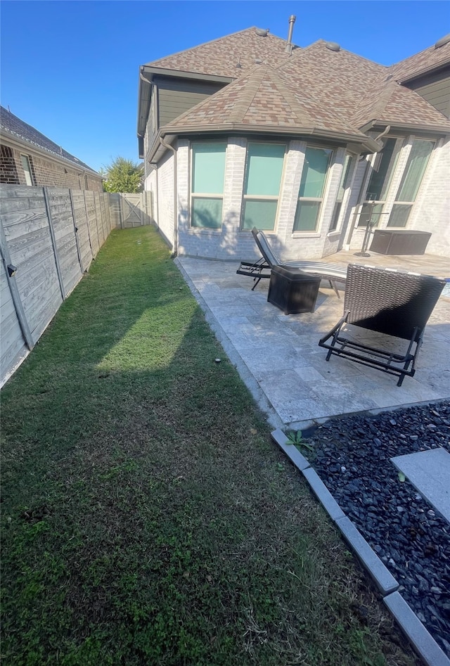 rear view of house featuring a patio and a lawn