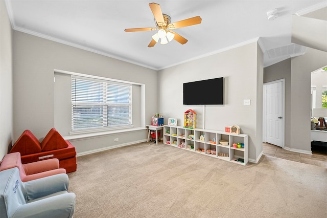 rec room with ceiling fan, a healthy amount of sunlight, light colored carpet, and ornamental molding