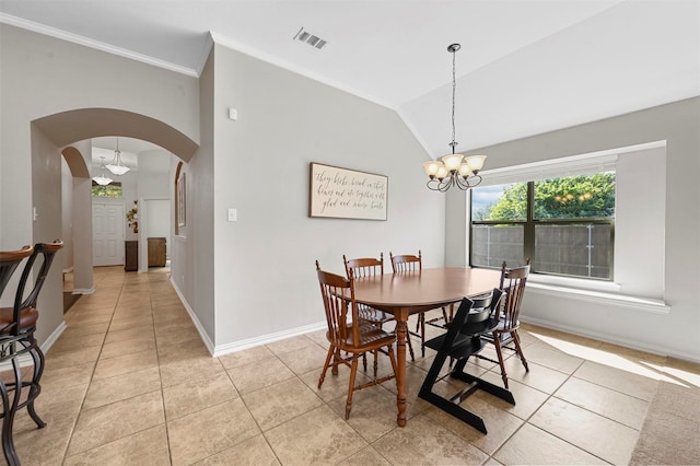 tiled dining room with lofted ceiling, ornamental molding, and a chandelier