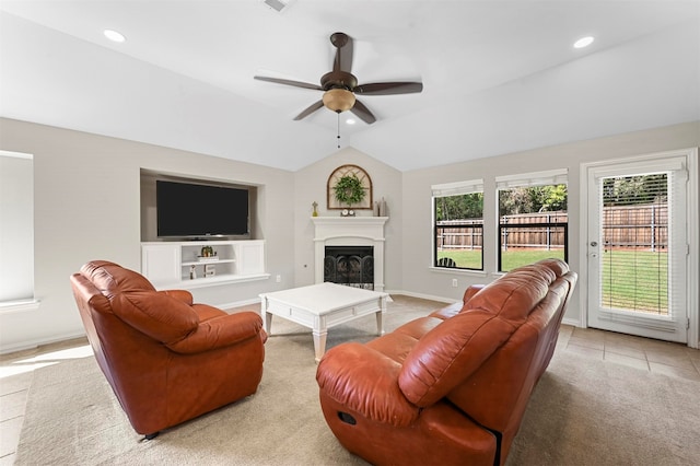 living room with ceiling fan, light tile patterned floors, and vaulted ceiling