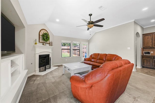 carpeted living room with ceiling fan, vaulted ceiling, and ornamental molding