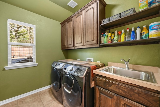 washroom with cabinets, washing machine and dryer, light tile patterned flooring, and sink