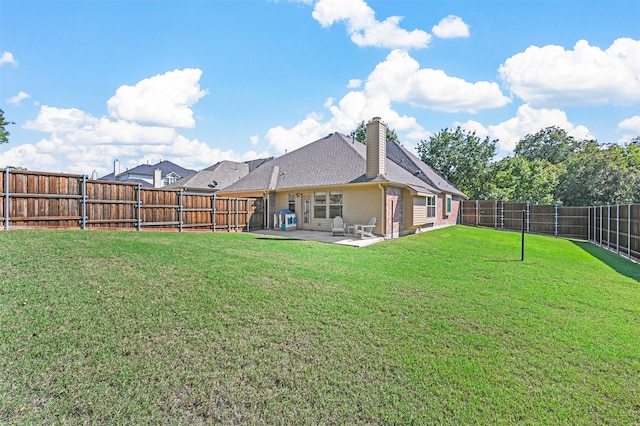 back of property with a patio area and a yard