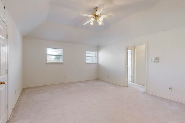 carpeted empty room featuring ceiling fan and vaulted ceiling