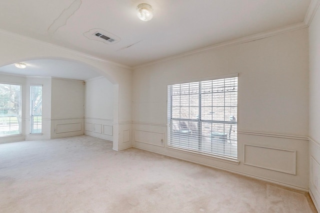 unfurnished room featuring light carpet, crown molding, and a healthy amount of sunlight