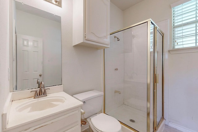 bathroom featuring vanity, walk in shower, and toilet