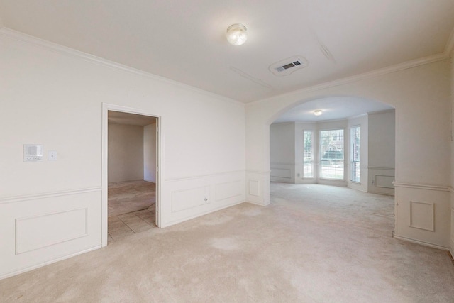 spare room featuring ornamental molding and light carpet