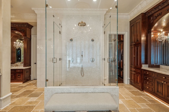 bathroom featuring crown molding, an inviting chandelier, vanity, and a shower with shower door