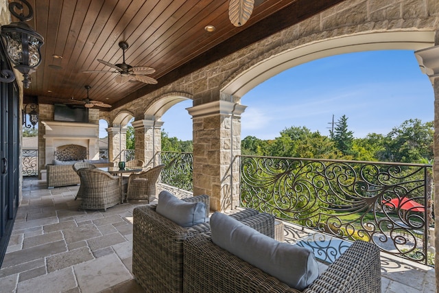 view of patio / terrace featuring an outdoor living space with a fireplace and ceiling fan