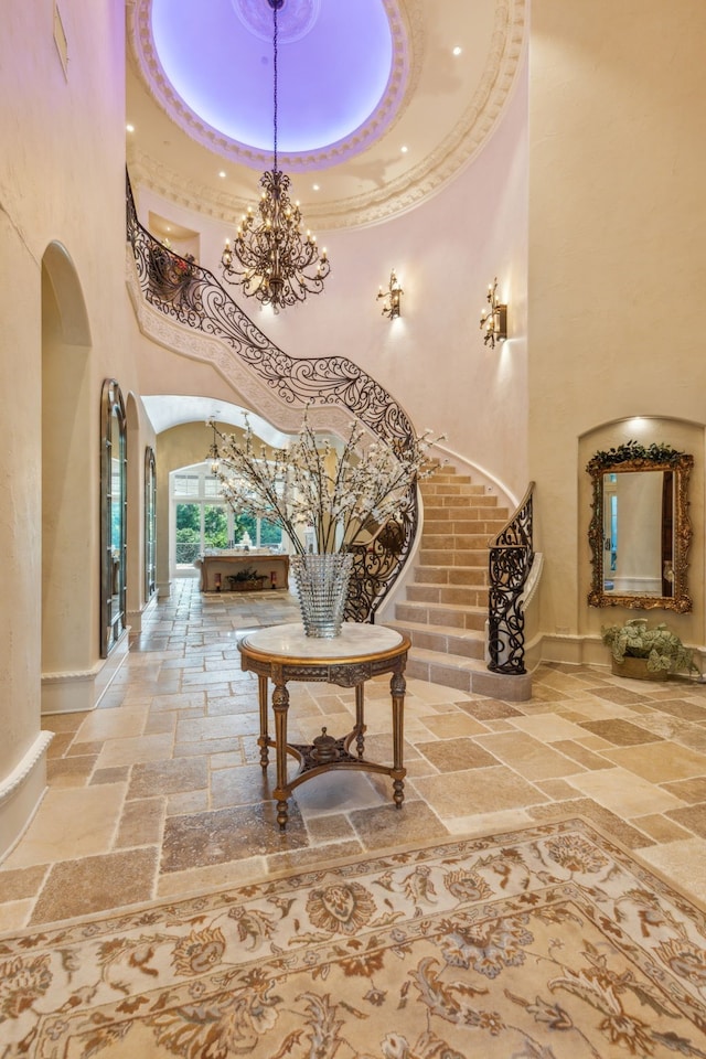 corridor featuring a notable chandelier and a high ceiling