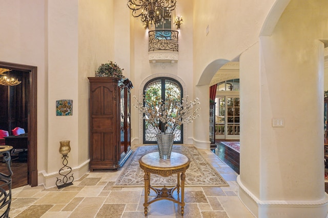 foyer entrance featuring a towering ceiling and a chandelier