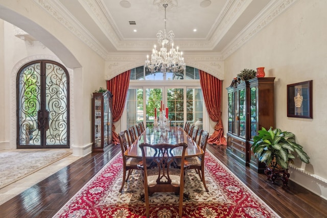 dining room featuring a high ceiling, crown molding, dark hardwood / wood-style flooring, a raised ceiling, and french doors