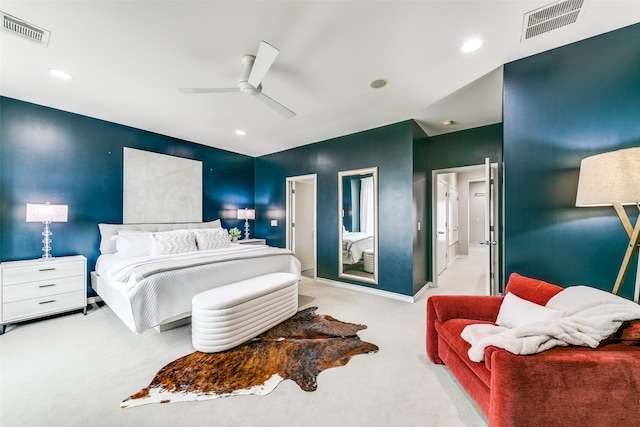 carpeted bedroom with ensuite bath and ceiling fan