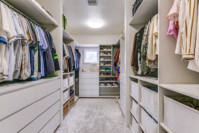 walk in closet featuring light colored carpet